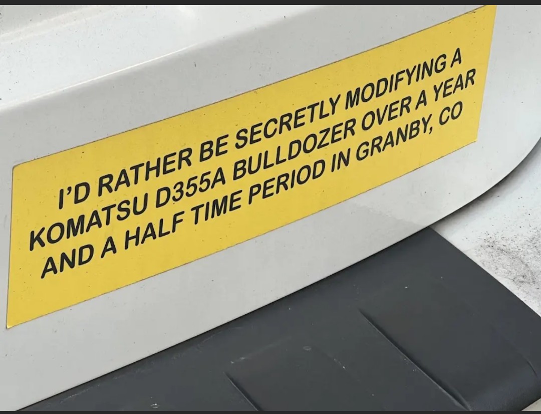 A bumper sticker that reads: "I'd rather be secretly modifying a Komatsu D377A Bulldozer over a year and a half time period in Granby, CO." This references a real life incident.